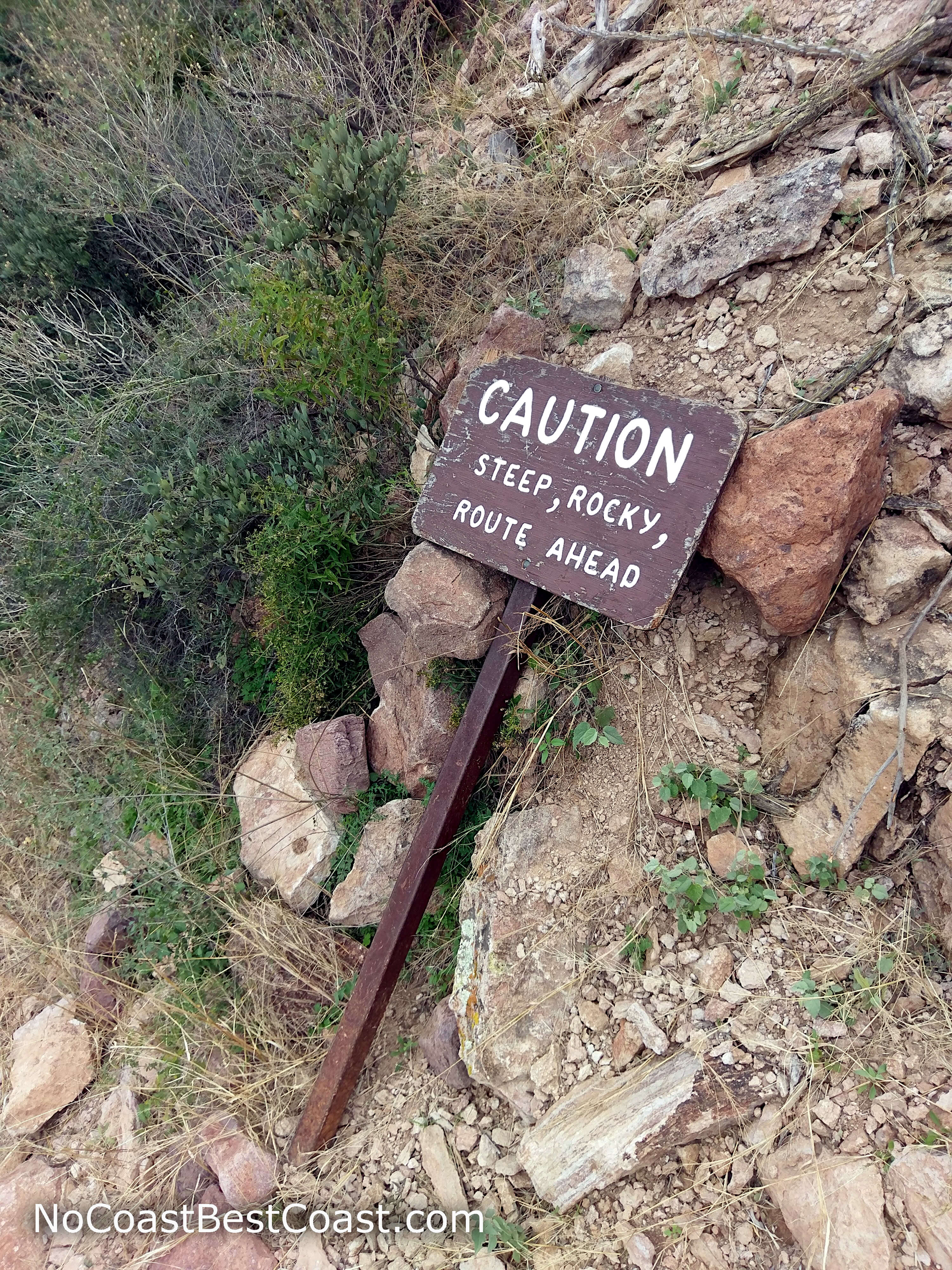 The downed trail sign warns of the dangerous route ahead