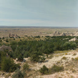 The view of the juniper forest below with the visitor center and the town of Interior in the distance