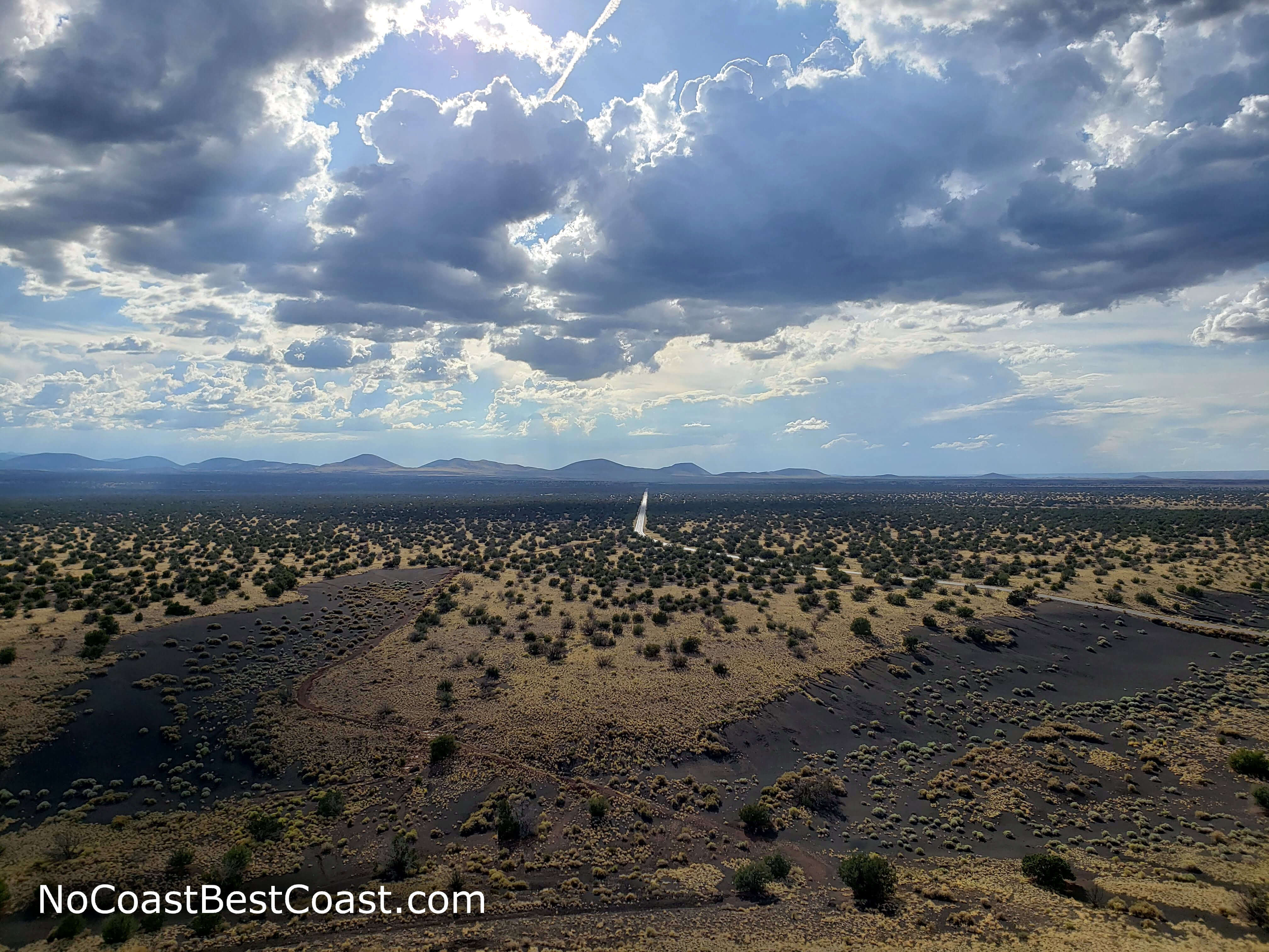 The empty road cutting through the vast desert as seen from the top of another peak on the way to Doney Mountain